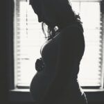 Silhouette pregnant woman holding her belly